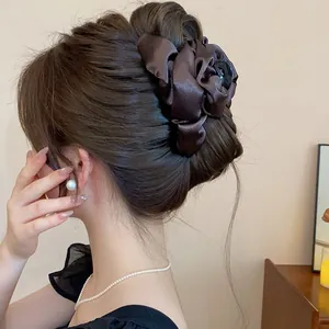Dettaglio di una molletta per capelli in raso marrone stile francese su un modello