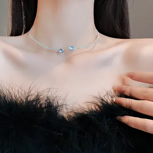 Detailed macro shot of minimalist silver choker necklace with two sparkling blue heart zircon stones