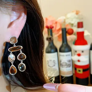 Close-up detail of vintage silver teardrop dangle earrings with amber faceted stones
