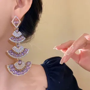 Close-up detail of elegant tiered fan-shaped dangling earrings with purple stones