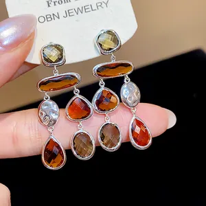 Close-up of elegant vintage brown glass teardrop earrings on a white jewelry card.