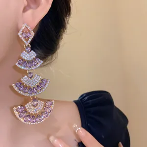 Close-up view of elegant purple fan-shaped drop earrings encrusted with sparkling diamonds