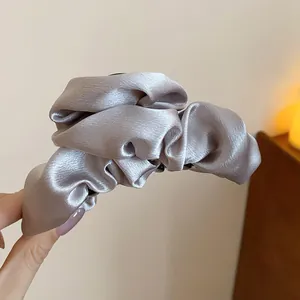 Primo piano dei dettagli di un elegante fermaglio per capelli in raso grigio champagne chic
