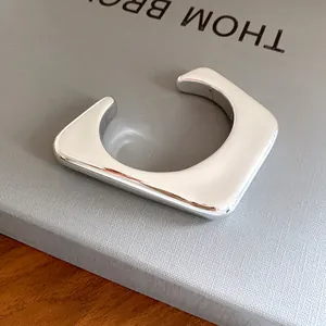 Détail macro d'un bracelet jonc argenté géométrique irrégulier au fini métallique lisse