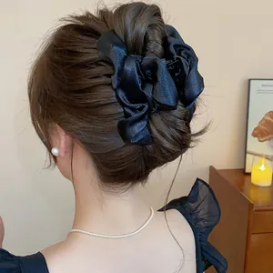 Dettaglio di una grande pinza per capelli in raso nero con fiocco in un'acconciatura