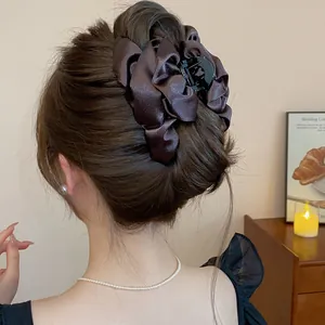 Vista dettagliata di un'elegante pinza per capelli in raso marrone in uno chignon di classe
