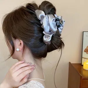 Primo piano di un elegante fermaglio per capelli in raso argento su uno chignon