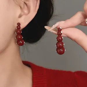 Elegant close-up of vintage red geometric earrings with white polka dots for women