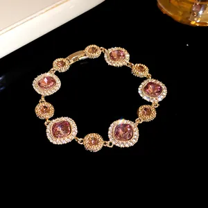 Vista dettagliata di un elegante bracciale dorato con pietre rosa scintillanti