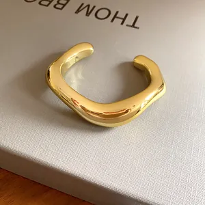 Vue détaillée d'un bracelet jonc ouvert doré poli de forme géométrique irrégulière