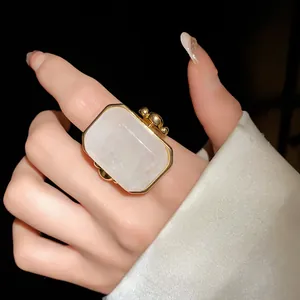 Dettaglio ravvicinato di un grande anello quadrato in pietra naturale con bordo oro