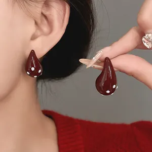 Detailed view of elegant vintage dark red waterdrop earrings with white polka dot patterns