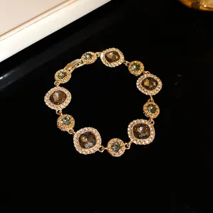 Dettaglio macro di bracciale dorato con gemme fumé e alone di cristalli