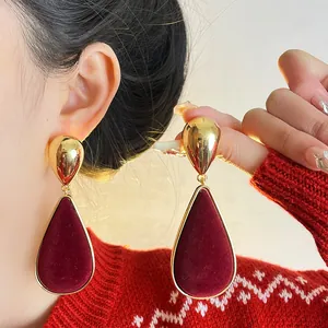 Detail view of retro burgundy velvet teardrop earrings with elegant gold finish
