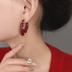 Close-up of vintage burgundy red teardrop hoop earrings with white polka dots