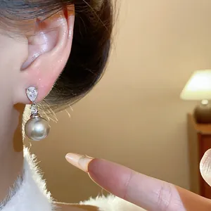 Close-up of elegant S925 silver needle pearl stud earring with teardrop zircon