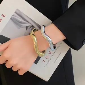 Détail de joncs métalliques ondulés irréguliers et épais avec des finitions en or et en argent