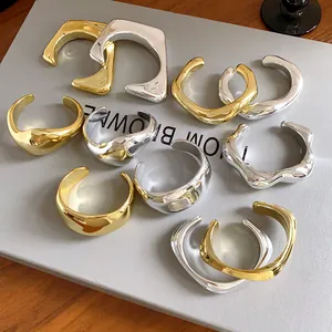 Gros plan de bracelets ouverts géométriques irréguliers en finitions or et argent