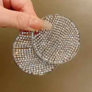 Close-up detail of oversized silver circle earrings with shimmering crystal pavé