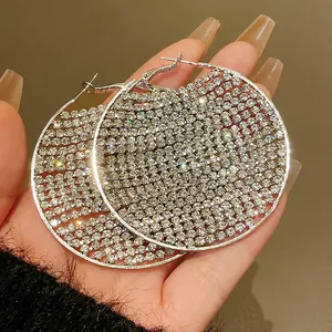 Macro view of oversized silver hoop earrings encrusted with sparkling clear zircons