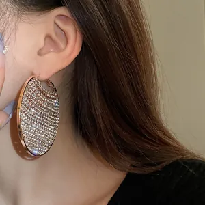 Detailed view of oversized rose gold hoop earrings paved with shiny zircons