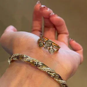 Close-up of a vintage-style double-layered gold ring with zircon coin details on hand.