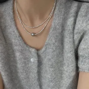 Double layered broken silver chain necklace with a metallic grey pearl pendant