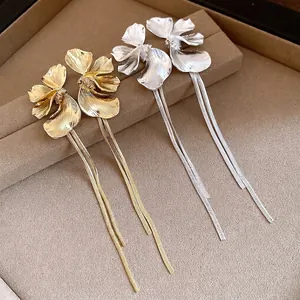 Elegant gold and silver flower tassel drop earrings on a jewelry display tray.