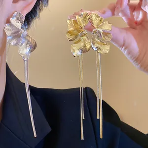 Detailed view of elegant flower-shaped earrings with long delicate metallic tassels