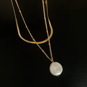 Elegant double-layered gold necklace featuring a lustrous flat white pearl pendant detail