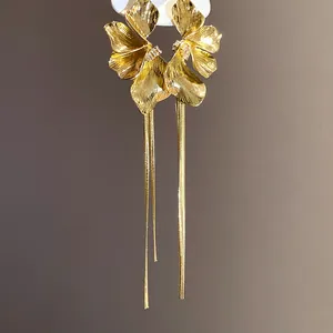 Detailed close-up of vintage gold flower tassel earrings with intricate textures.
