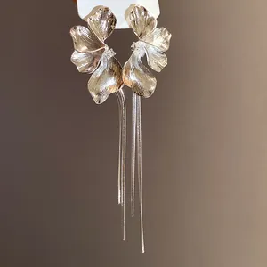 Close-up of elegant silver flower earrings with long delicate tassel drop design