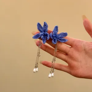 Detailansicht blauer Perlen-Ohrringe mit langer Silberkette und Perlenanhängern