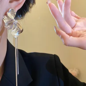 Detailed view of silver flower tassel earrings on model with elegant vintage style