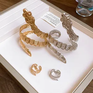 Macro view of gold and silver snake-shaped rings and cuffs set in a display