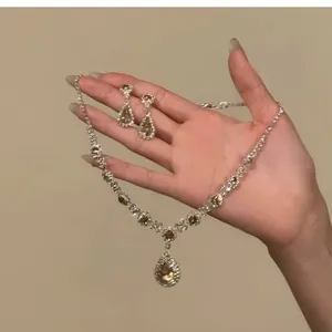 Nahaufnahme eines eleganten Strass-Halsketten- und Ohrring-Sets in Champagner-Farben