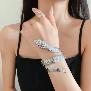 Detail view of a stylish silver snake-shaped arm cuff and ring set worn by a model.