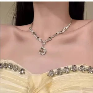 Detailaufnahme einer eleganten Strass-Halskette mit Wassertropfen an einem Model getragen