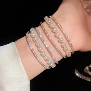 Elegant triple-layer bracelet with sparkling rhinestones and white pearls on model wrist