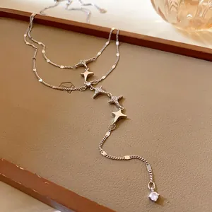 Macro view of double-layer stainless steel star necklace with glittering zirconia.