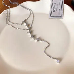 Close-up detail of silver stainless steel double-layer necklace with dainty zircon stars