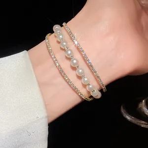 Close-up of a three-layer luxury bracelet with shimmering rhinestones and pearls on wrist
