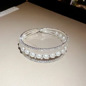 Triple-layer open bangle with elegant white pearls and sparkling pavé rhinestones.