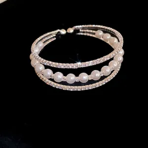 Close-up of elegant three-layer open bangle with shimmering rhinestones and pearls