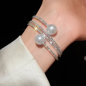 Detailed macro shot of a sparkling three-layer open bracelet with pearls on a wrist