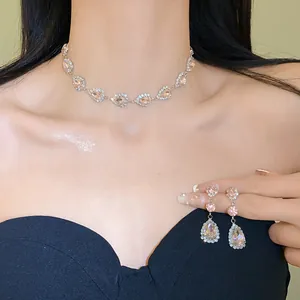 Detailed view of luxury teardrop necklace and earring set with pink gemstones.