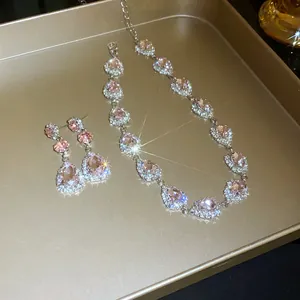 Elegant jewelry set featuring pink water-drop crystals displayed on a golden tray