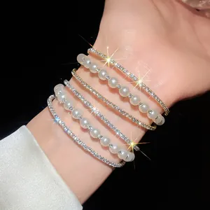 Detailed view of sparkling multi-layer rhinestone and pearl stackable bracelets on wrist