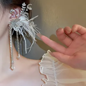 Detailed view of an elegant rhinestone ear cuff with white feathers and long crystal tassels