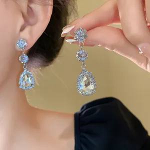 Macro view showing the sparkling teardrop crystals and intricate setting of the earrings